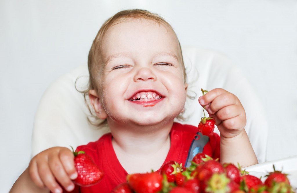 Happy Toddler Boy Eating Strawberries
